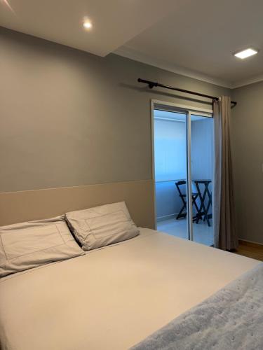 a bedroom with a bed and a view of the ocean at Flat Red Sorocaba - Blue in Sorocaba