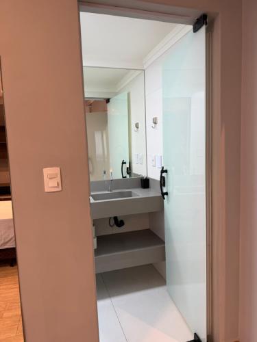 a bathroom with a sink and a mirror at Flat Red Sorocaba - Blue in Sorocaba