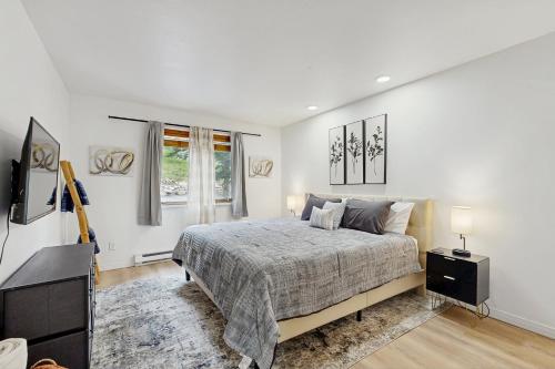a white bedroom with a bed and a television at Elevation Hideaway in Durango Mountain Resort