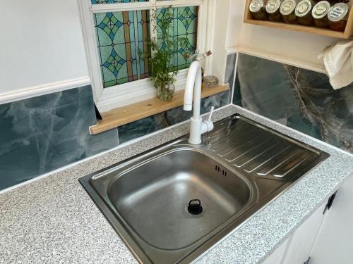 a sink in a kitchen with a stained glass window at Dove Cottage Chatka 35 Chalmová in Bystričany