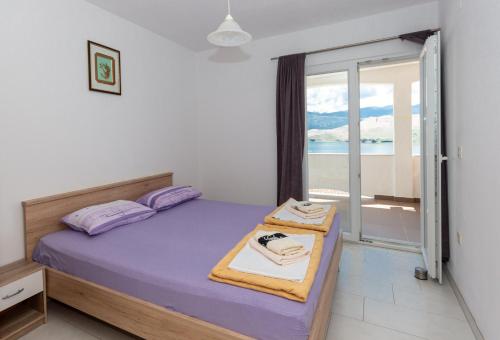 a bedroom with a bed with a view of the ocean at Apartmants 38 in Pag