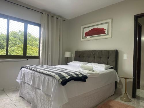 a bedroom with a bed and a window at Apartamentos nadai apto 202 in Foz do Iguaçu