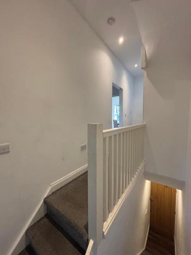 a staircase in a house with white walls at Bel Palace in Hackbridge