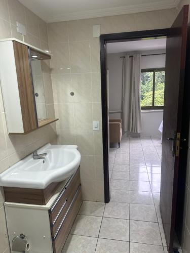 a bathroom with a sink and a mirror at Apartamentos nadai apto 202 in Foz do Iguaçu
