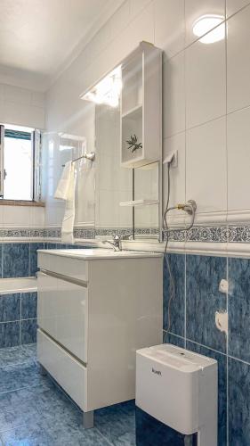 a white bathroom with a sink and a mirror at Port'Espada Countryhouse in Marvão