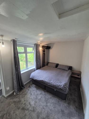 a small bedroom with a bed and a window at Seascape Spa Retreat in Niton