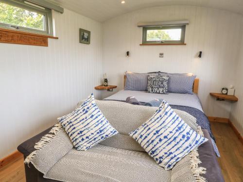 a bedroom with two beds and a couch with pillows at Damsons in Taunton