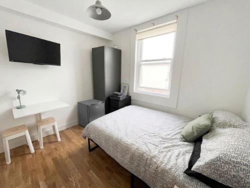 a bedroom with a bed and a desk and a window at Casa Azul in Plumstead