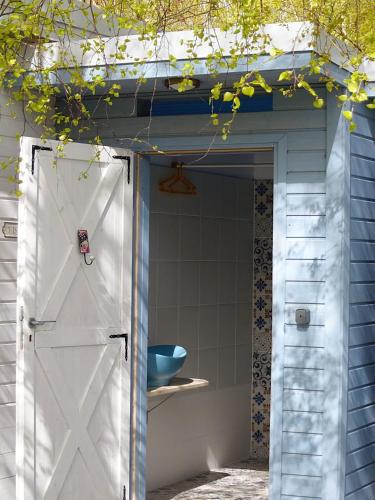 a white door in a shed with a blue bowl at Zapach Morza - A Casa Mia in Niechorze