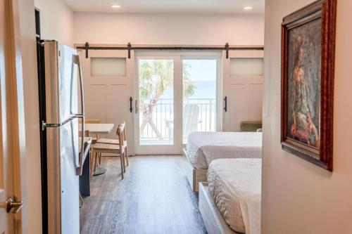 a bedroom with two beds and a table and a door at Driftwood Inn in Mexico Beach