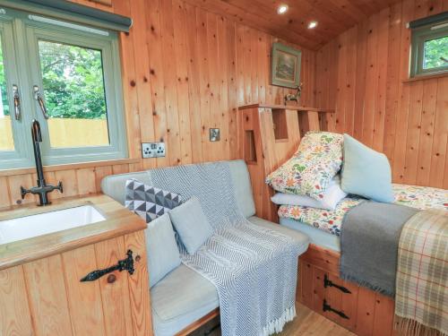 a tiny house bathroom with a sink and a bed at Pippins in Taunton