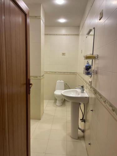 a white bathroom with a sink and a toilet at Dream House Hostel & Hotel in Yerevan