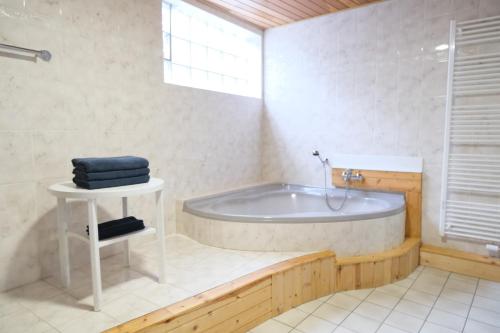 a white bathroom with a tub and a window at Blue Lagoon Holiday Apartments & Double Room with Balcony in Nehren