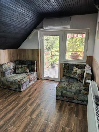 a large living room with two beds and a window at Fűzfa Apartmanház in Tamási