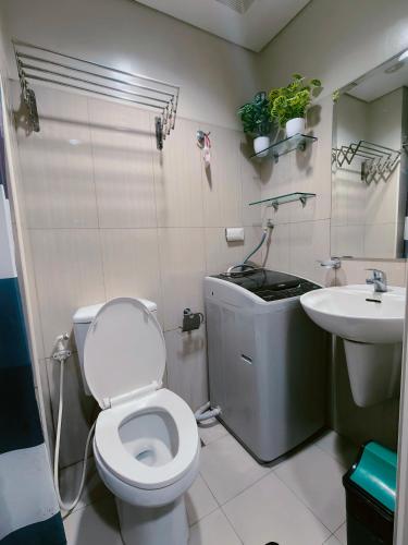 a bathroom with a toilet and a sink at MOA shell residences - JOSH in Manila