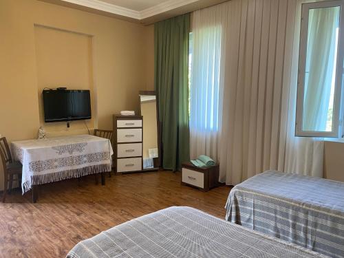 a hotel room with two beds and a television at Quiet house in Buknari