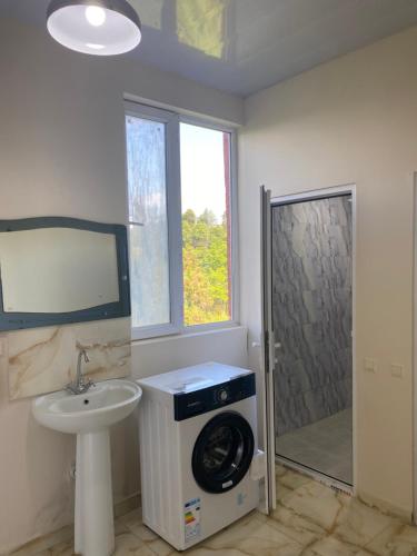 a bathroom with a washing machine and a sink at Quiet house in Buknari