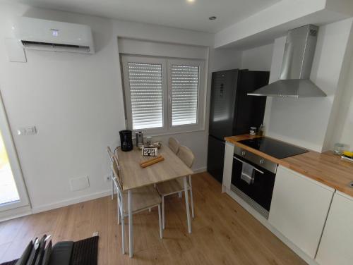 a kitchen with a wooden table and a black refrigerator at Xeliña B in A Estrada