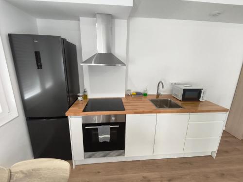 a kitchen with a black refrigerator and a sink at Xeliña B in A Estrada