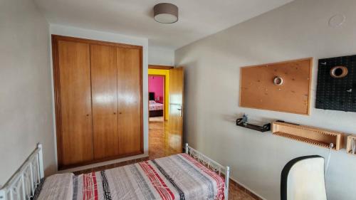 a bedroom with a bed and a wooden door at Casa Mediterrània in Xeraco