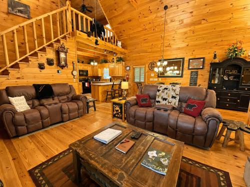 a living room with couches and a table in a cabin at Lords View in Mineral Bluff