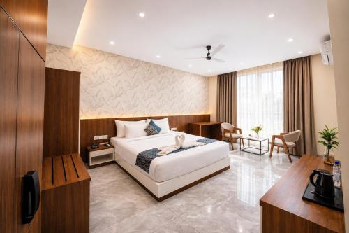 a hotel room with a bed and a desk at The Sapphire Hotel in Belgaum