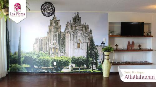 a large painting of a building on the wall at Suites Las Plazas in Cuernavaca