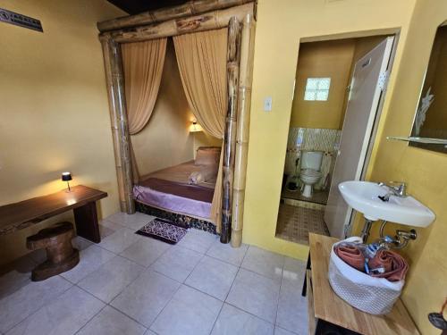 a bathroom with a bed and a sink in a room at Sumatra Inn & Travel in Bukit Lawang