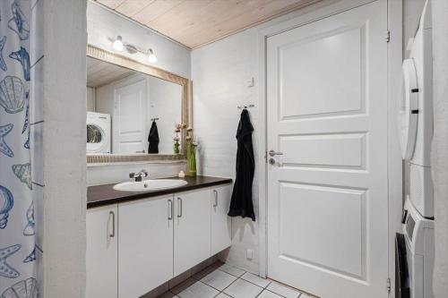 a white bathroom with a sink and a mirror at 1056-Klegod-Lyngvejen-10 in Klegod