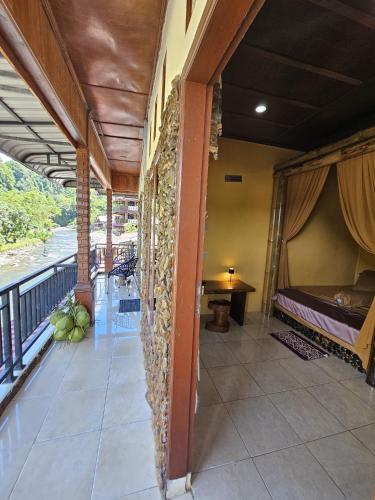 a room with a bed and a balcony at Sumatra Inn & Travel in Bukit Lawang