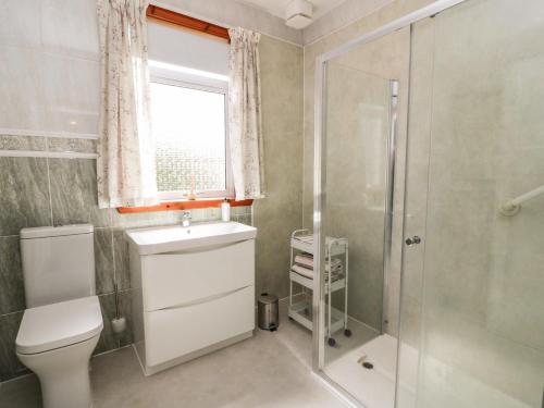 a bathroom with a toilet sink and a shower at Sundale in Strathaven