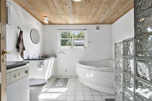 a bathroom with a tub and a toilet and a sink at C11206-Hemmet-Ildervej-7 in Hemmet