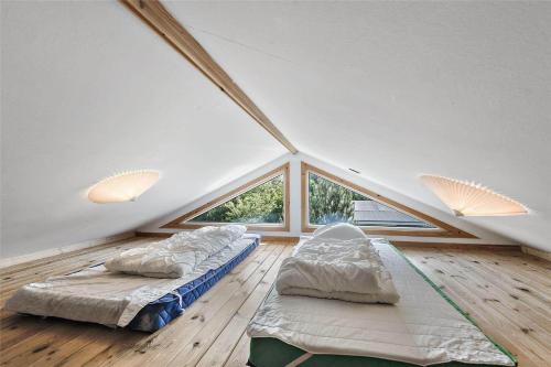 a attic room with two beds and a window at C11206-Hemmet-Ildervej-7 in Hemmet