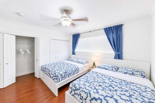 a bedroom with two beds and a ceiling fan at The Golfstream Dunes Villa in Hallandale Beach