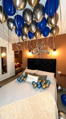 a bed with blue and silver balloons hanging above it at Inn Home Aparta-Suite in Salento