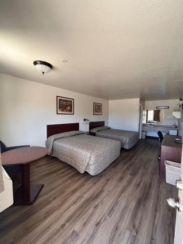 a hotel room with two beds and a table at Shady Motel in Caliente