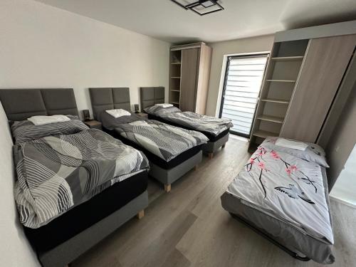 a room with three beds and a window at Apartmány Krymlov in Oleška