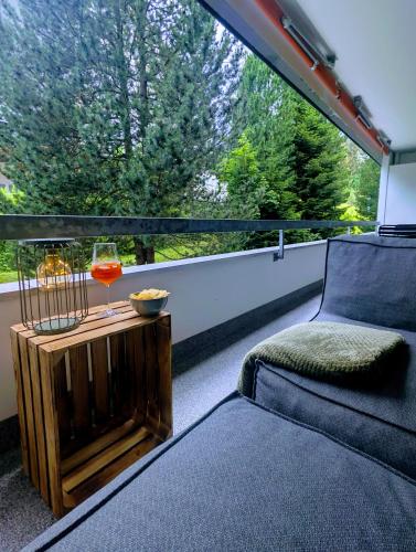 a room with a couch and a glass of wine at Ferienwohnung Flumserberg, Liftnähe & Gratis Parkplatz in Flumserberg