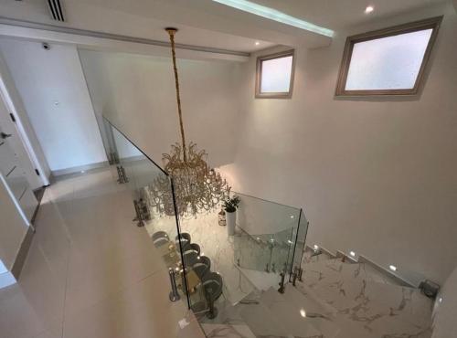 a staircase with a chandelier and a glass floor at Mansión Versace in Panama City