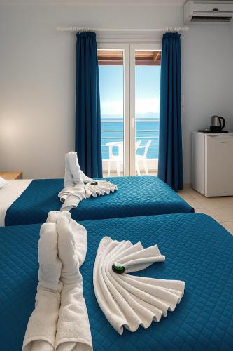 a bedroom with two beds with towels on them at Newquay beach club in Kavos