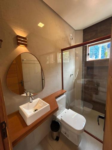 a bathroom with a sink and a mirror and a toilet at Casa Dona Amélia in Barreirinhas