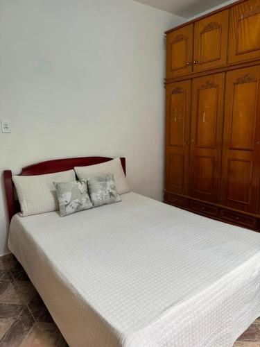 a bedroom with a large bed with a wooden cabinet at Sítio do Miguel in Barbacena