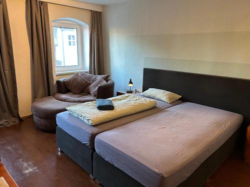 a bedroom with a bed and a chair in a room at Bester Blick auf Bautzen in Bautzen