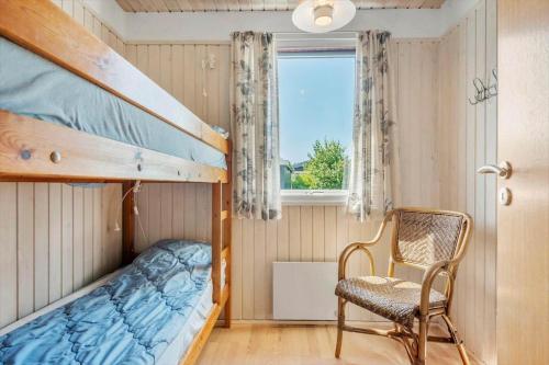 a bedroom with bunk beds and a chair and a window at 30061-Malling-Morbaervaenget-18 in Malling