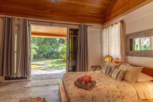 a bedroom with a bed with a large glass door at Our Beachfront Bungalow in Puerto Viejo