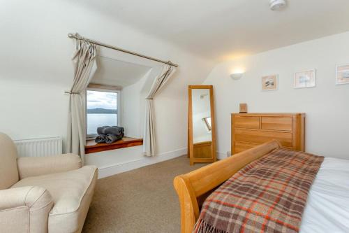 a bedroom with a bed and a chair and a mirror at 2 Bed in Strath oc-s44223 in Gairloch