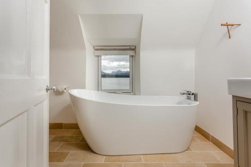 a white bath tub in a bathroom with a window at 2 Bed in Strath oc-s44223 in Gairloch