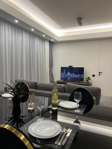 a living room with a couch and a table with wine glasses at PREMIUM Apartament & Wellness with jacuzzi, sauna , gym , pool in Bucharest