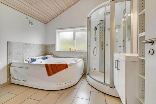 a white bathroom with a tub and a shower at C11331-Tarm-Brombaervej-5 in Tarm