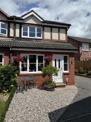 a house with a table and chairs in front of it at Number 30 The ORCHARDS in Middlewich